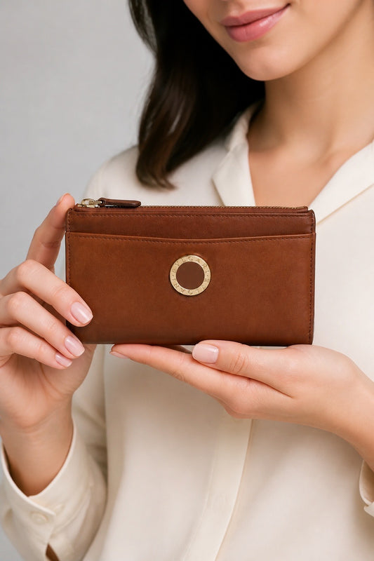 Main de femme portant un porte-monnaie Bvlgari en cuir – Seconde main luxe – VestiaireFMR Genève Suisse